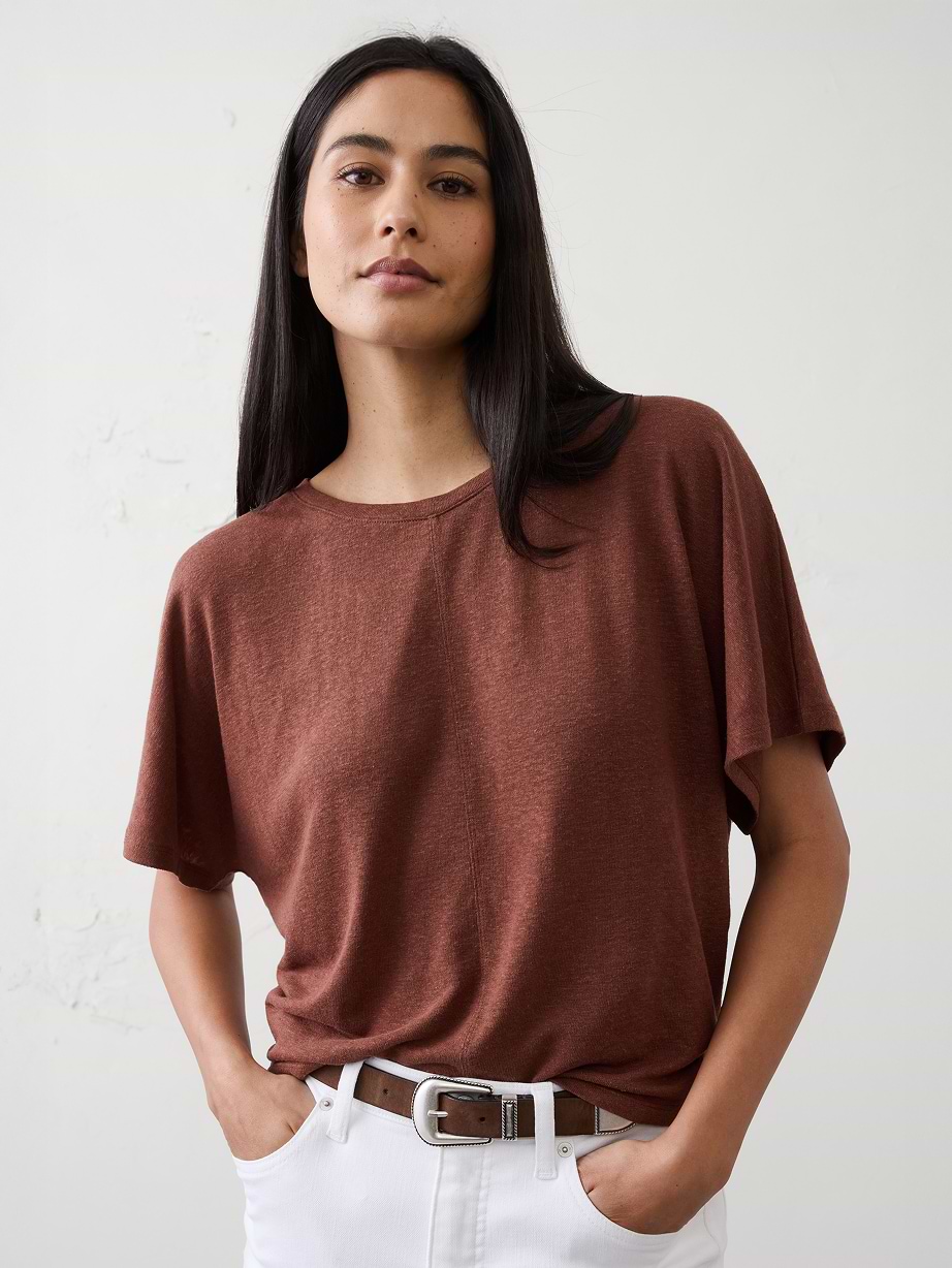 Woman in brown tee and white jeans.