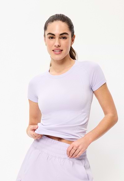 A female model wearing a lavender short sleeve athletic top.