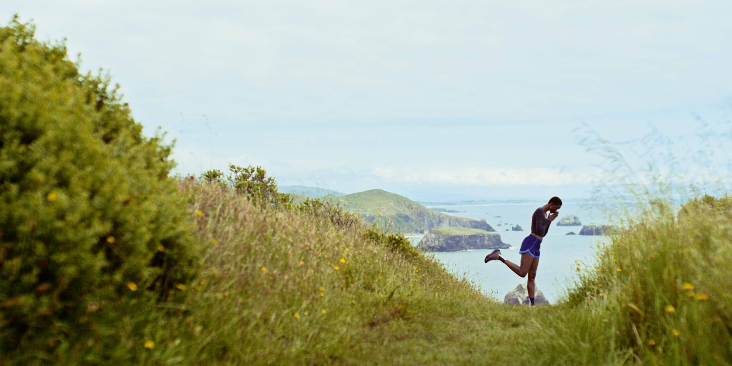 a man running on a trail near the ocean with a view of the ocean