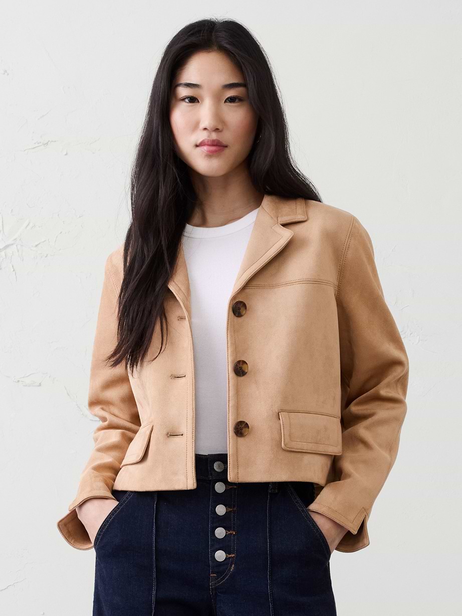 Woman in brown jacket and jeans.