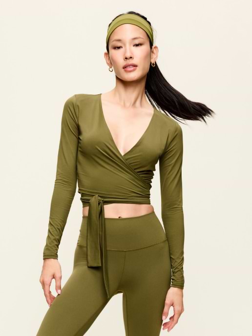 Person wearing an olive-green long-sleeve wrap crop top with matching leggings and headband, posing against a plain background.