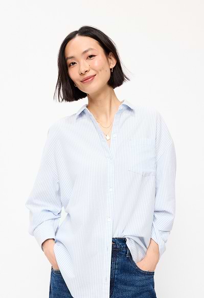 A female model wearing a light blue striped button-down shirt.