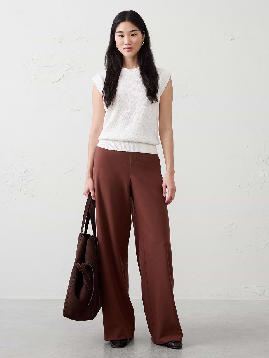 Woman in white top and brown pants.