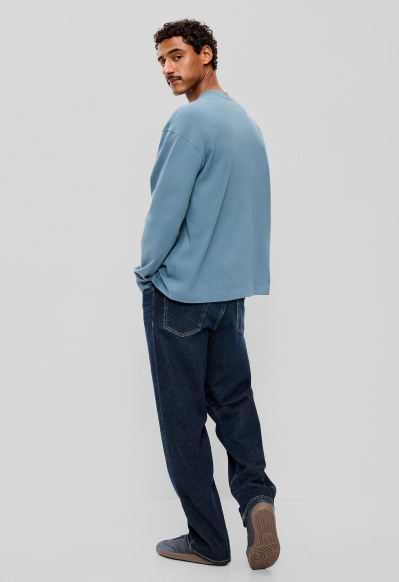 A male model wearing loose jeans.