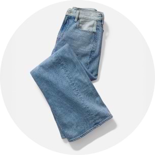 Folded light blue denim jeans on a white background.