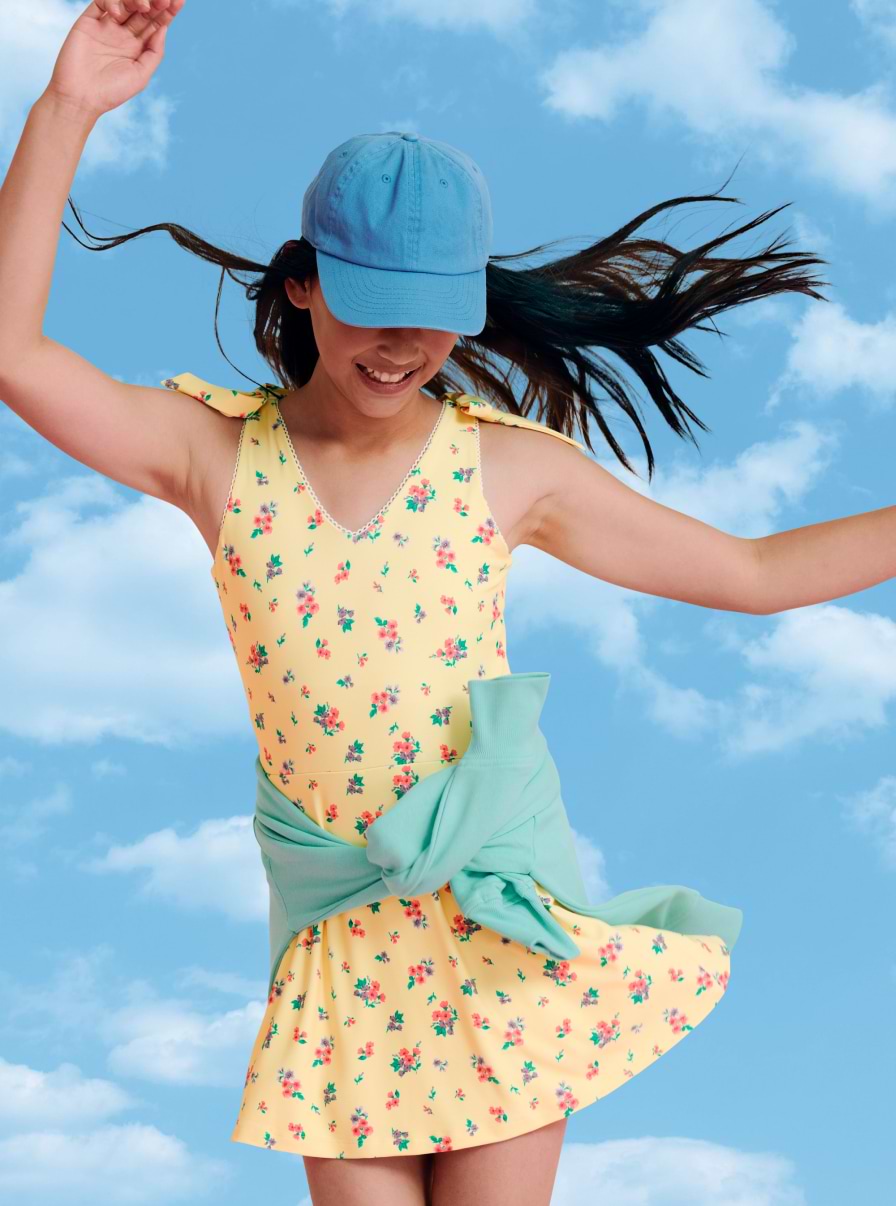 Young female model wearing a yellow floral active dress.