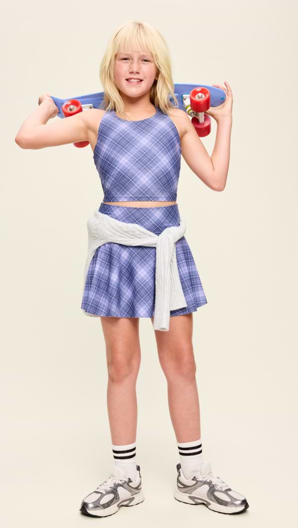 A young female model wears performance skort and sweatshirt.