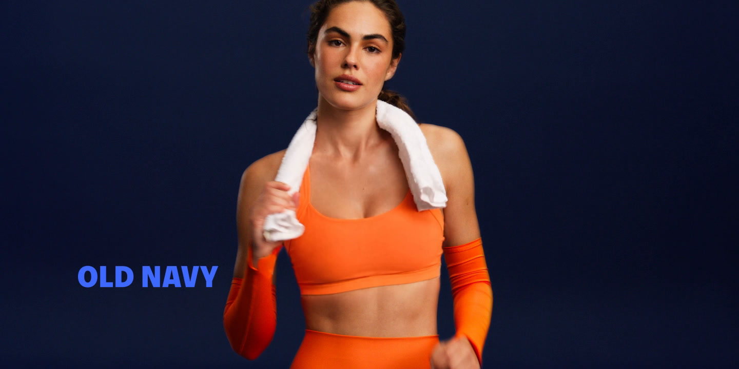 Person in orange activewear with a white towel; “OLD NAVY” text on a dark blue background.