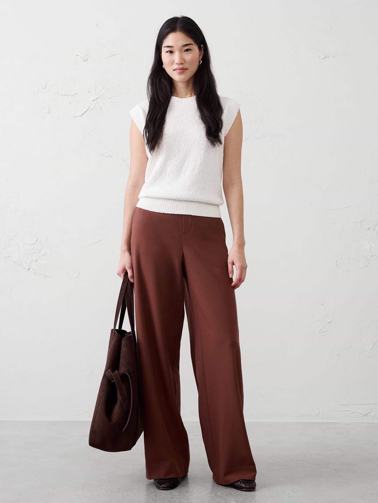 Woman in white top and brown pants.