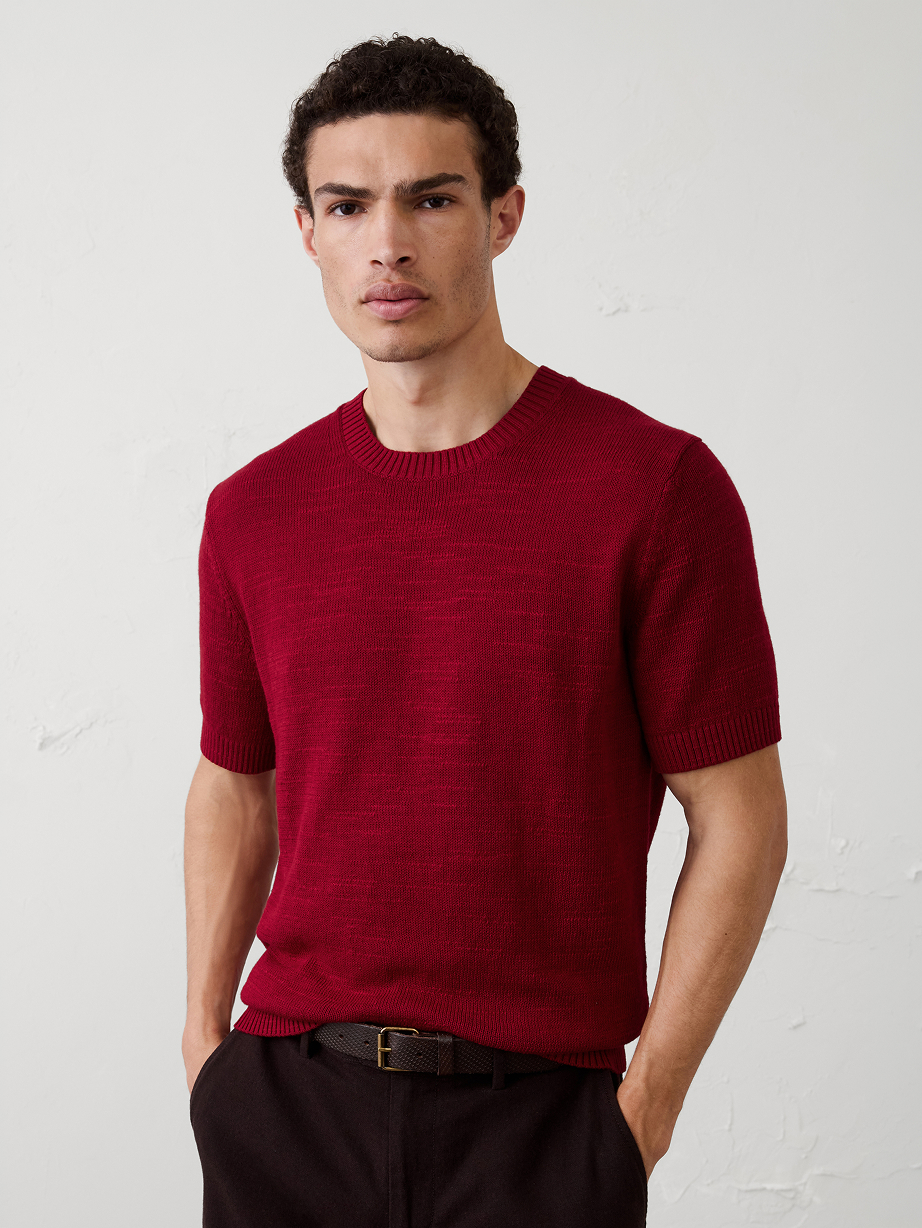 Man in red sweater shirt and black pants.