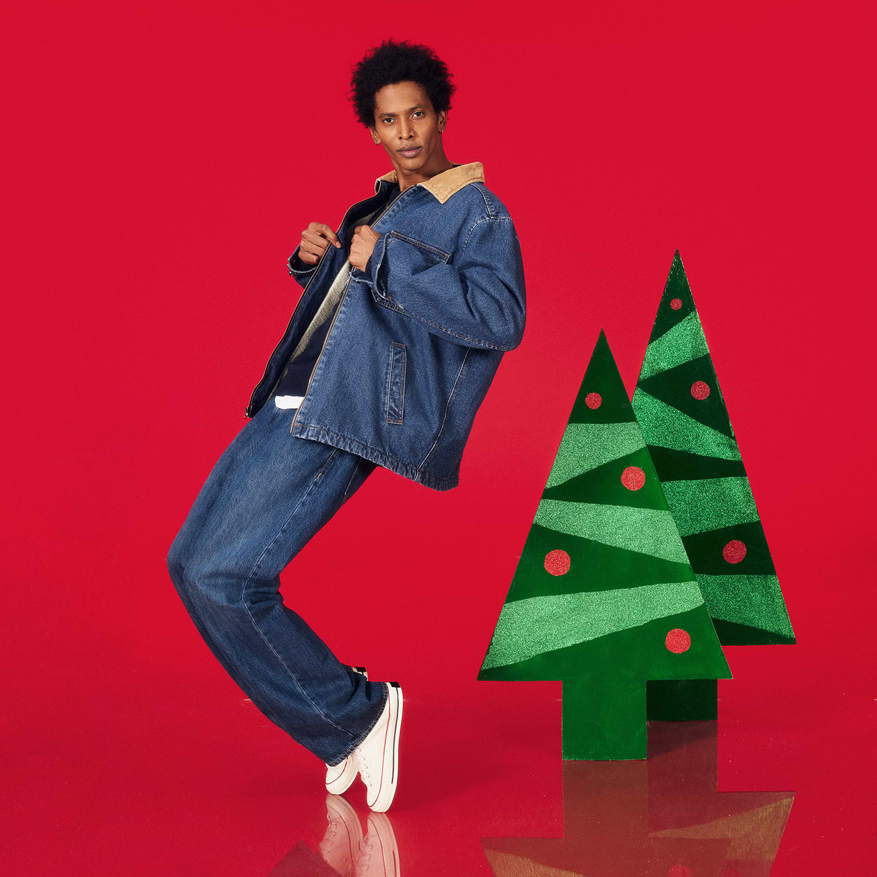 A male model wearing a jeans jacket and dark washed jeans.