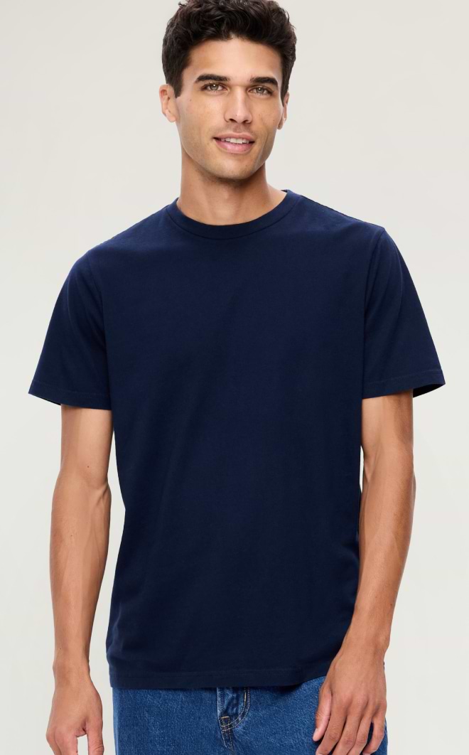 Person wearing a plain navy short-sleeve crew-neck T-shirt and blue jeans against a light background.