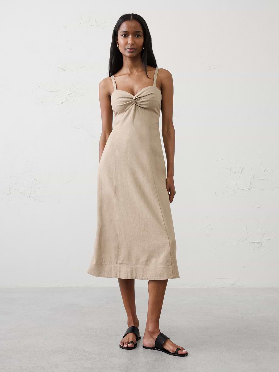 Woman in tan dress and sandals.