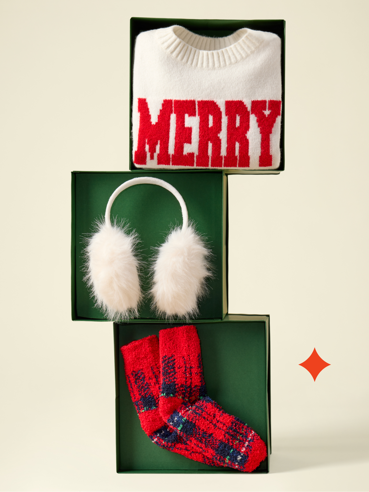 a gift box with a sweater, mittens and earmuffs on top