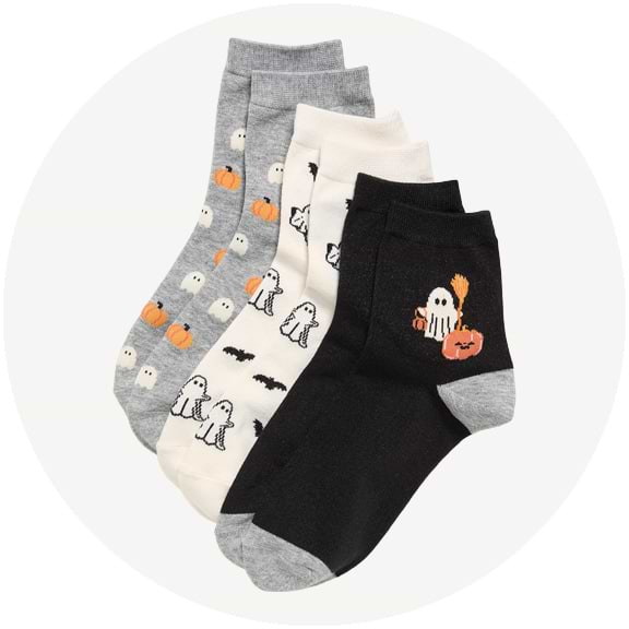 Four ankle socks in gray, cream, and black with Halloween designs: ghosts, pumpkins, bats, and dogs.