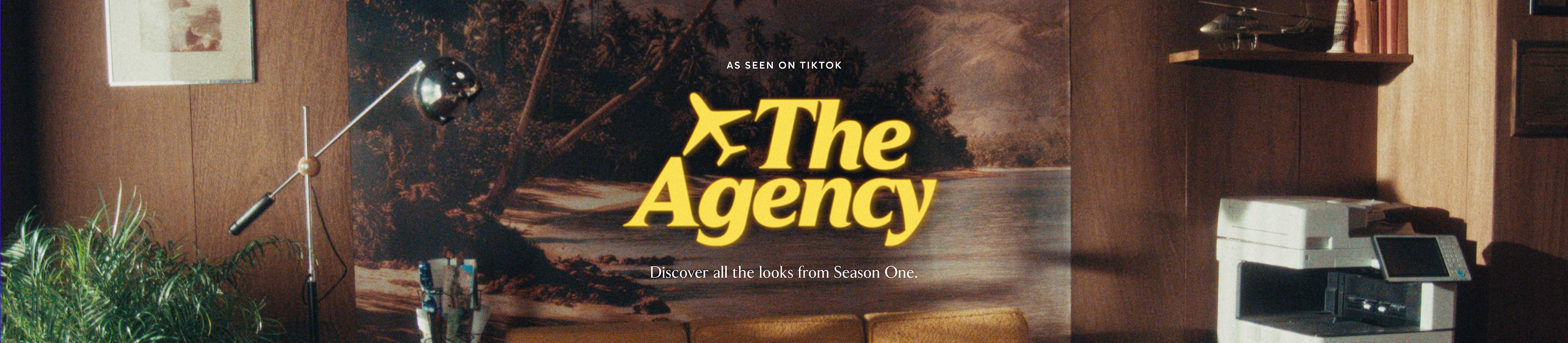 Retro wood‑paneled office with plants, lamp, and copier; centered poster reads “The Agency” with plane icon and tagline “As seen on TikTok—Discover all the looks from Season One.”