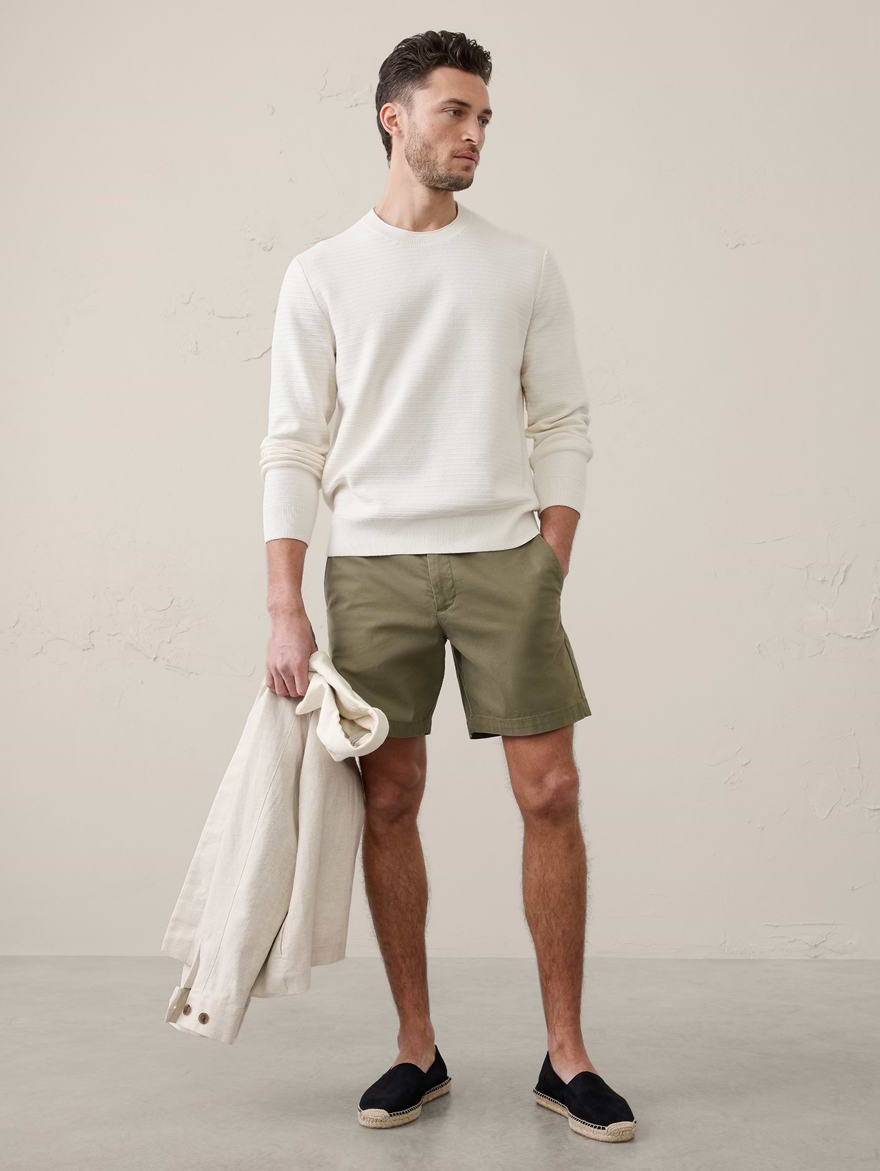Man in white sweatshirt and green shorts.