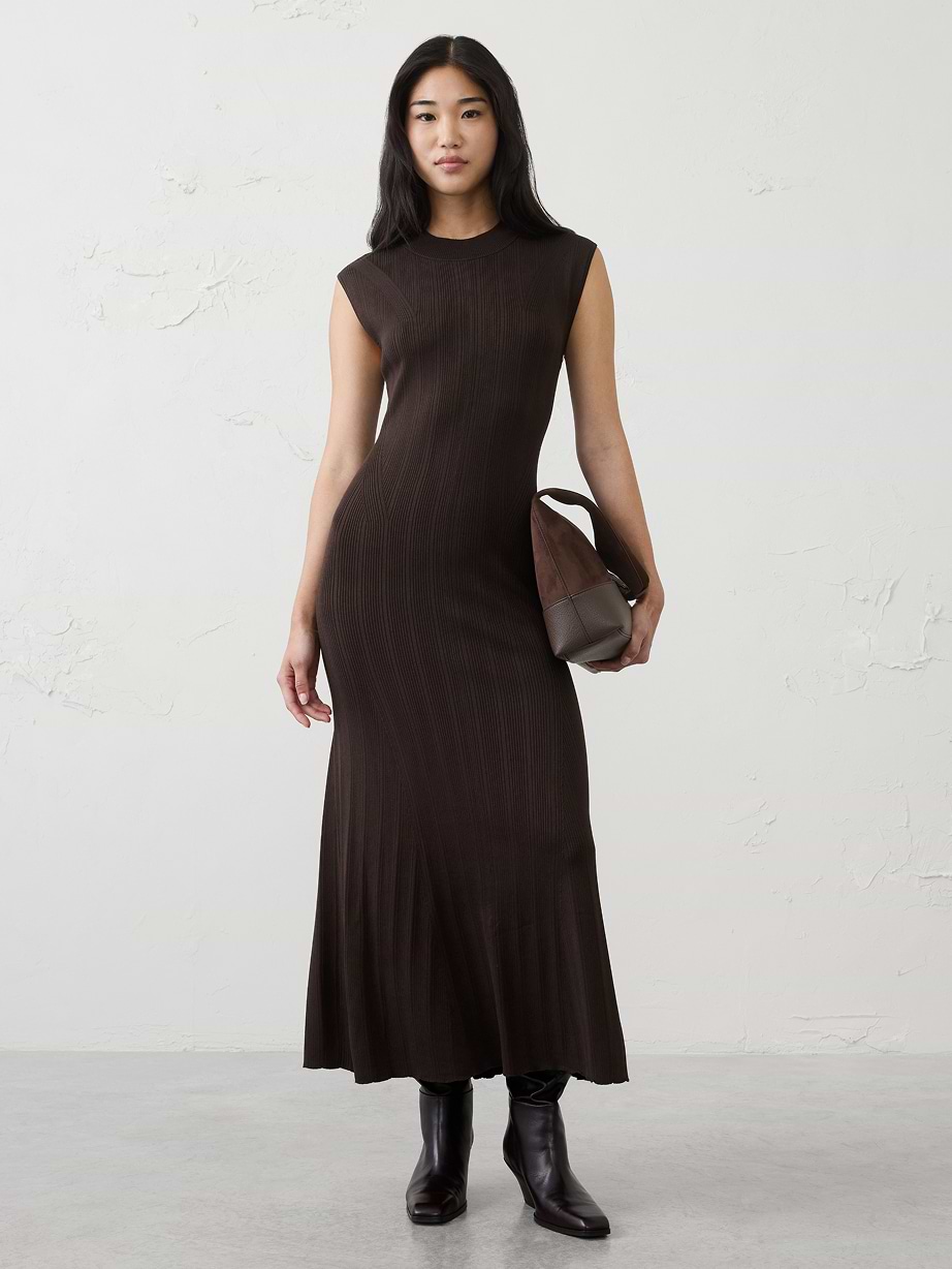 Person wearing a dark brown ribbed sleeveless maxi dress, holding a brown bag, with dark ankle boots.