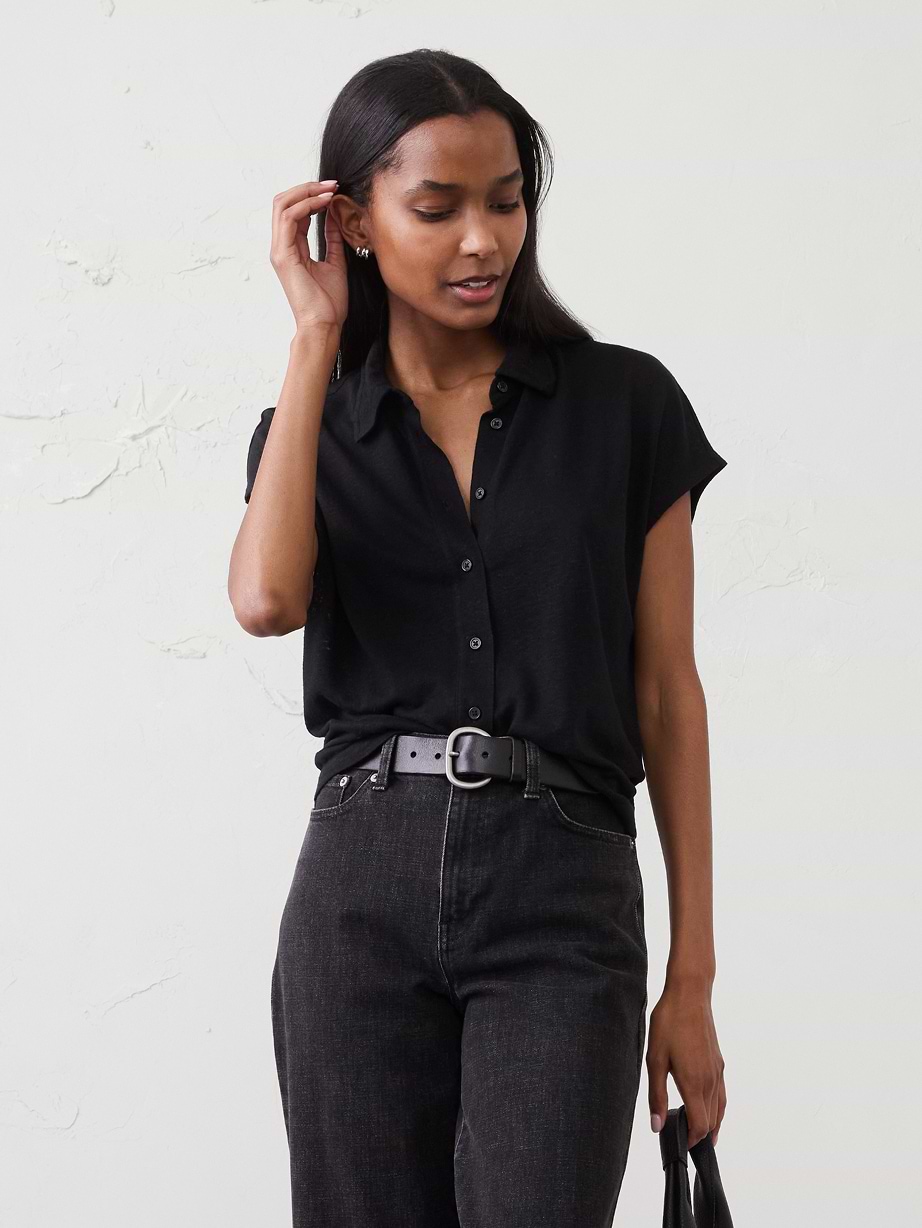 Woman in black top and black jeans.