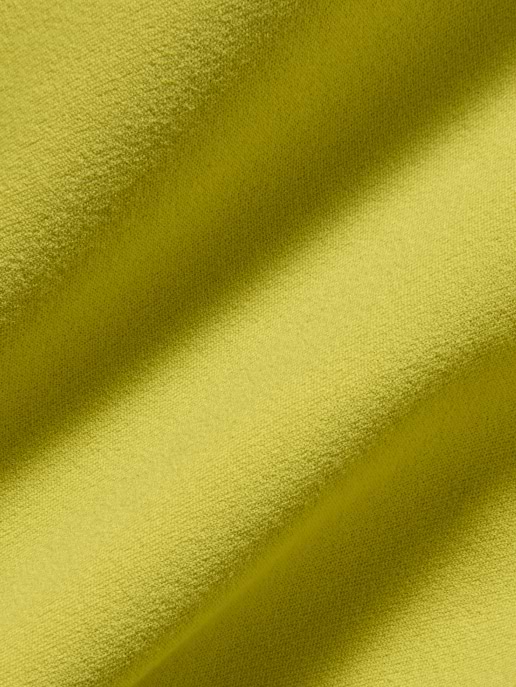 Close-up of textured lime-green fabric with soft diagonal folds.