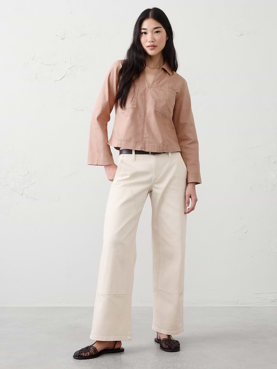 Woman in pink top and white pants.