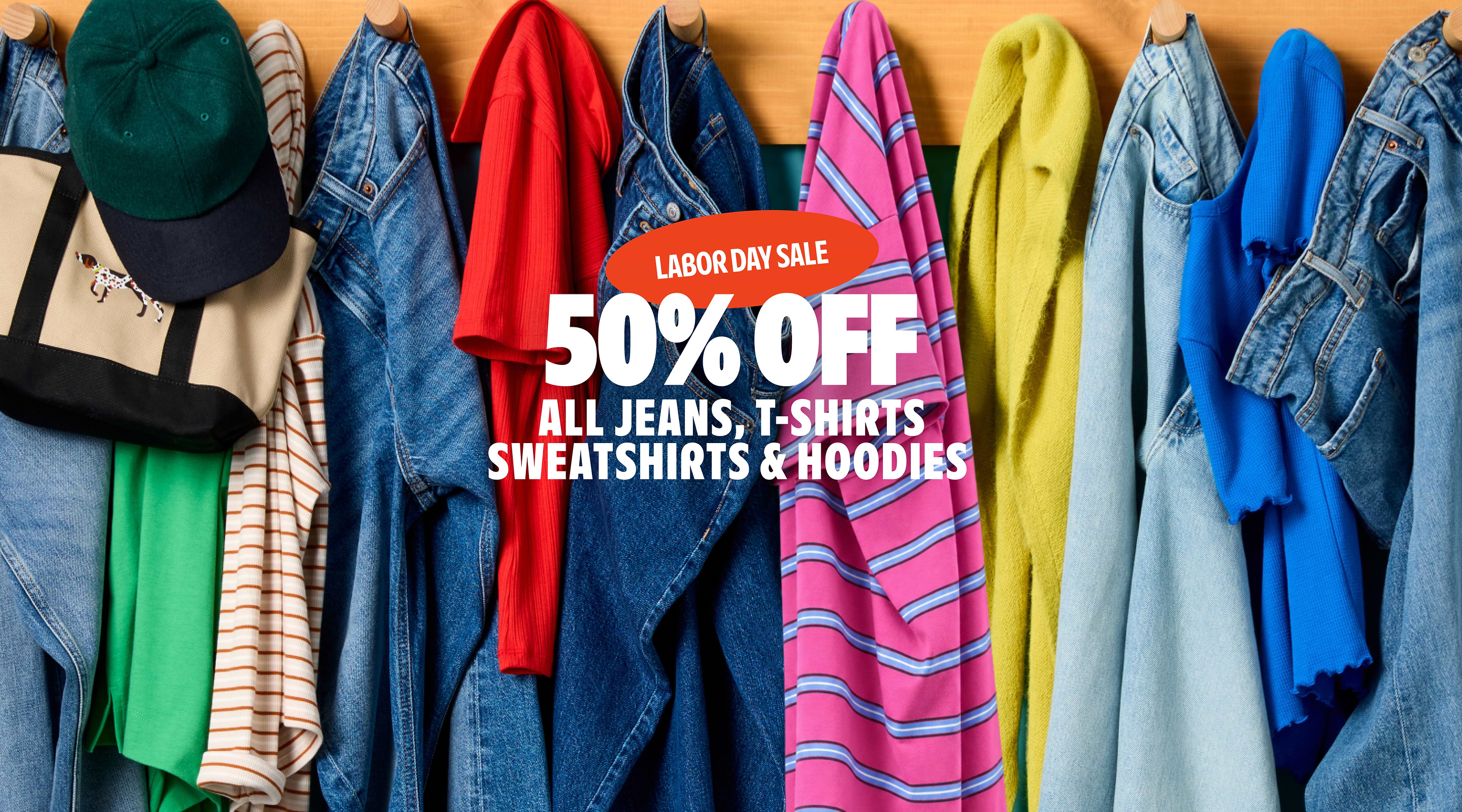 Labor Day sale: 50% off all jeans, T‑shirts, sweatshirts, and hoodies, shown over colorful clothes hanging on hooks.