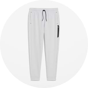 Pantalon de jogging en molleton gris pâle avec cordon de serrage noir, chevilles resserrées, poches latérales et poche zippée noire à droite.