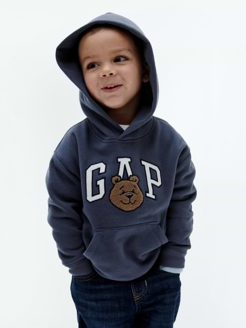 a young boy in a hoodie with a bear on it