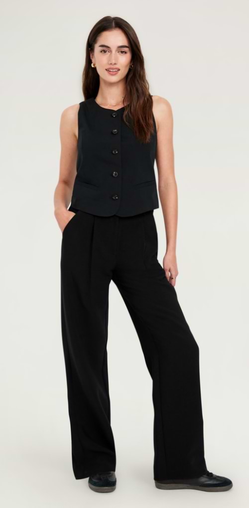 A woman in a black wide leg pant suit.