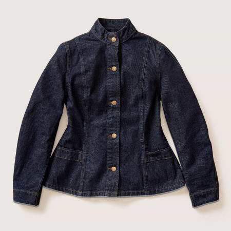 Dark indigo denim jacket with stand collar, brass buttons, and two front pockets.