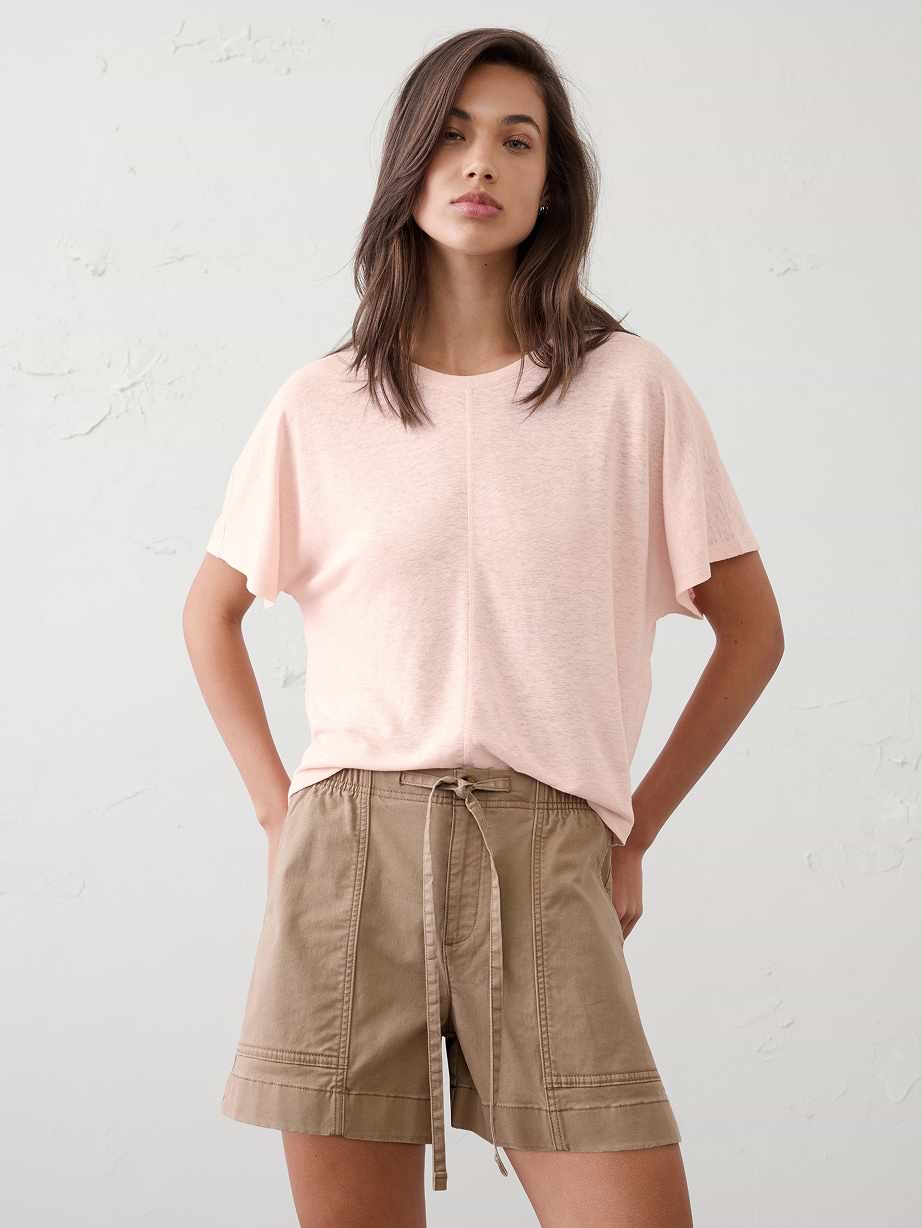 Woman in pink t-shirt and brown shorts.