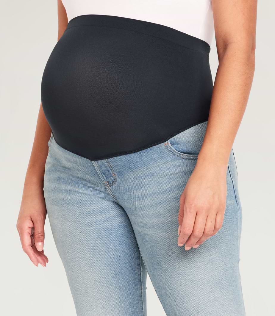 A pregnant model wearing over the bump maternity jeans.