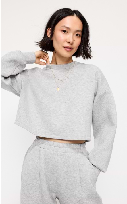 A female model wearing a grey Old Navy cropped sweatshirt.