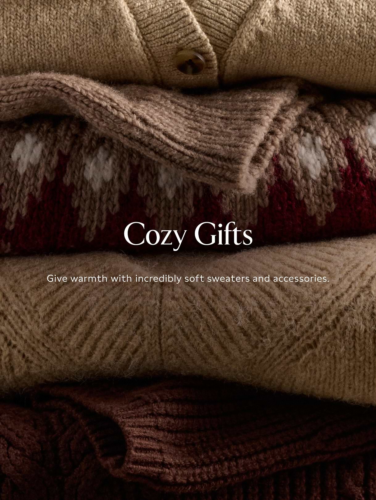 Stack of folded knit sweaters in warm earth tones; text reads “Cozy Gifts.”