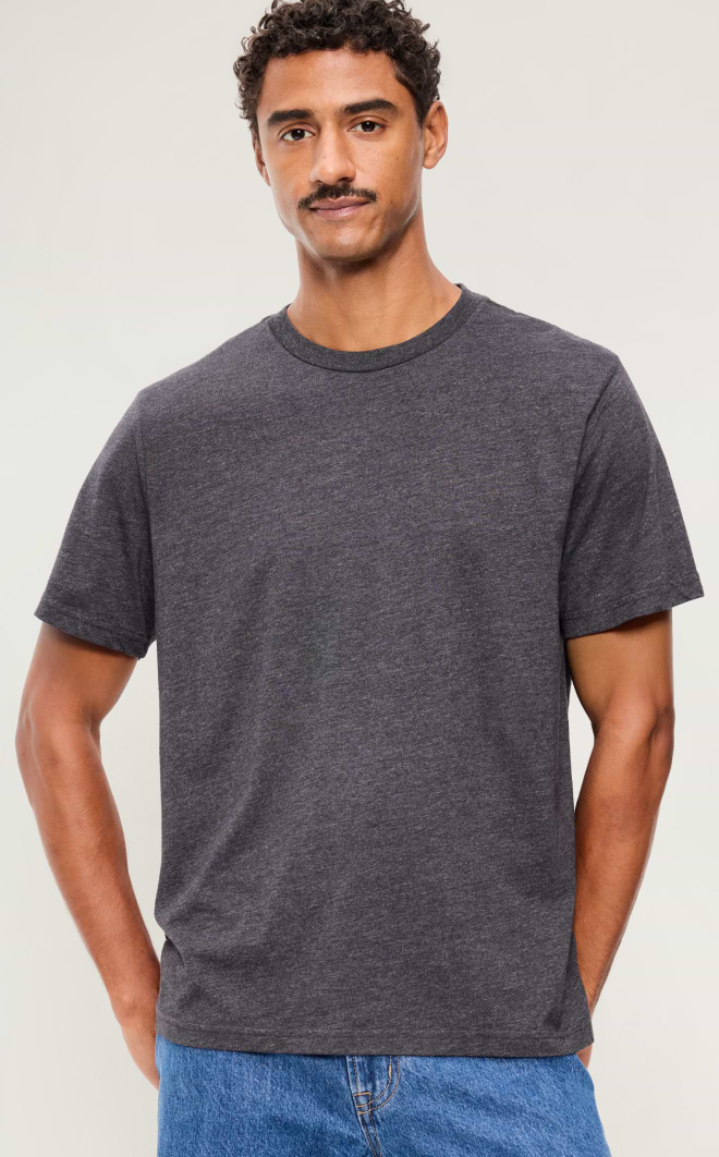 Person wearing a dark gray short‑sleeve crewneck T‑shirt with blue jeans against a plain background.