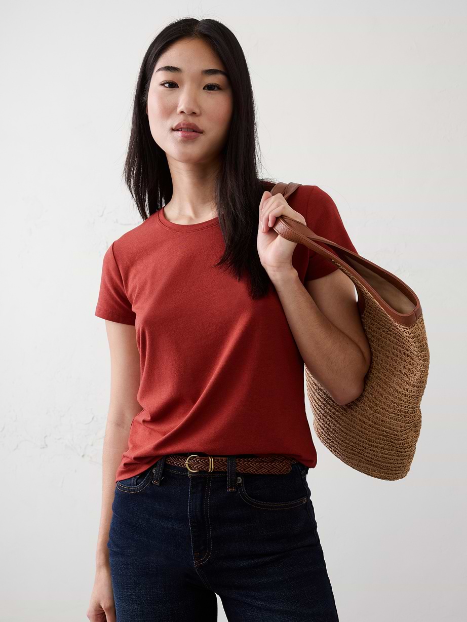 Woman in red t-shirt and dark jeans.