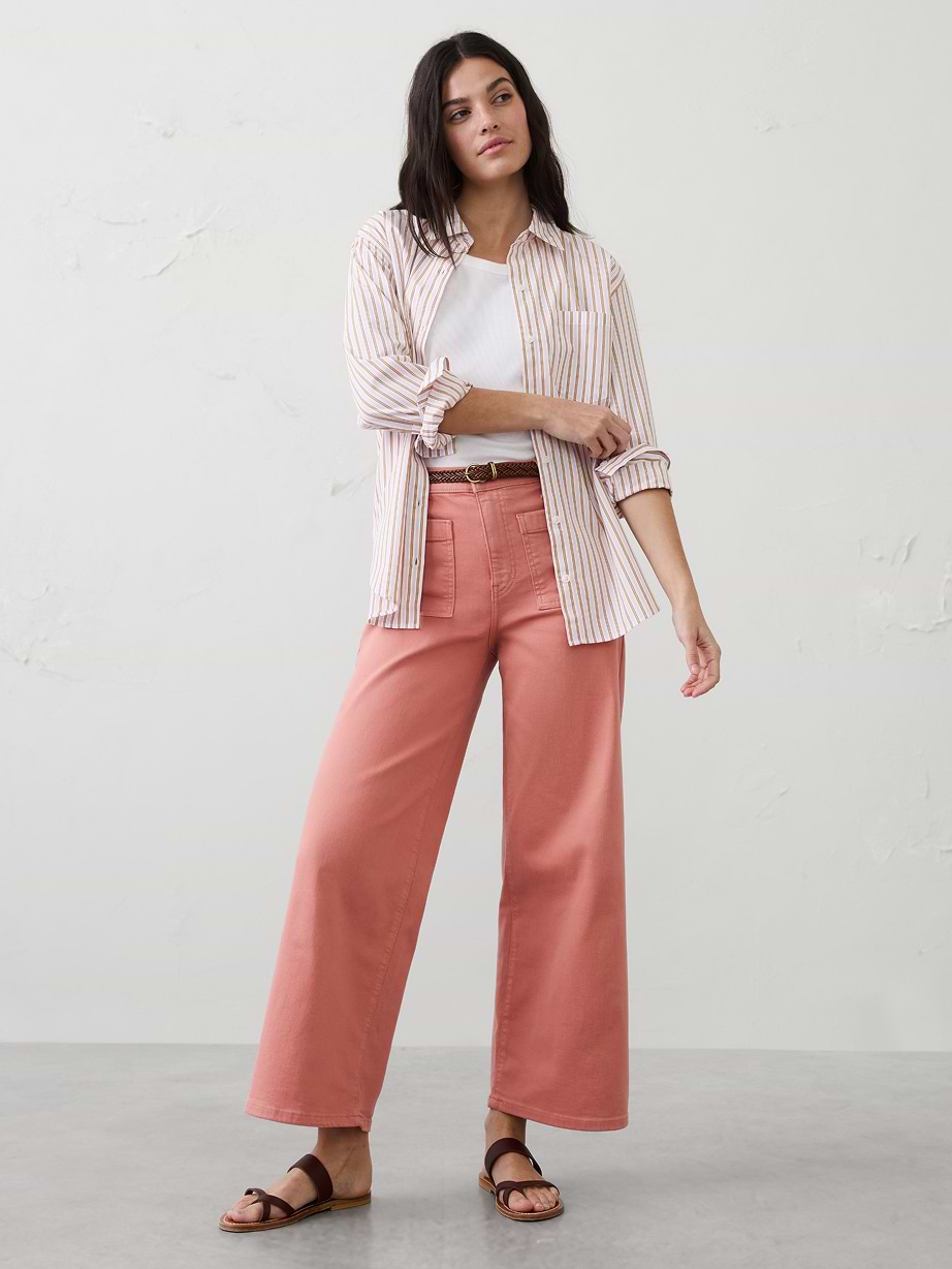 Woman in striped shirt, white tshirt, and coral pants.
