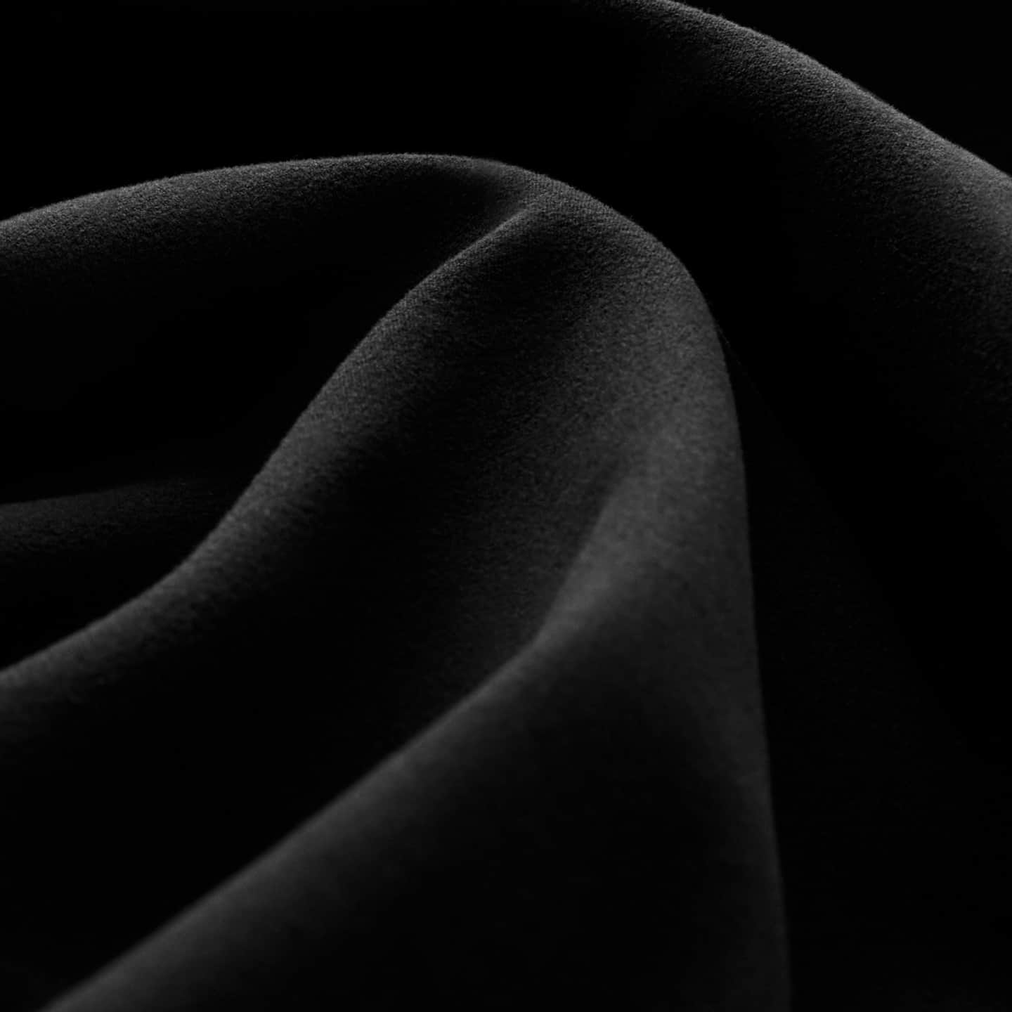 Close-up of black fabric with soft, velvety folds.