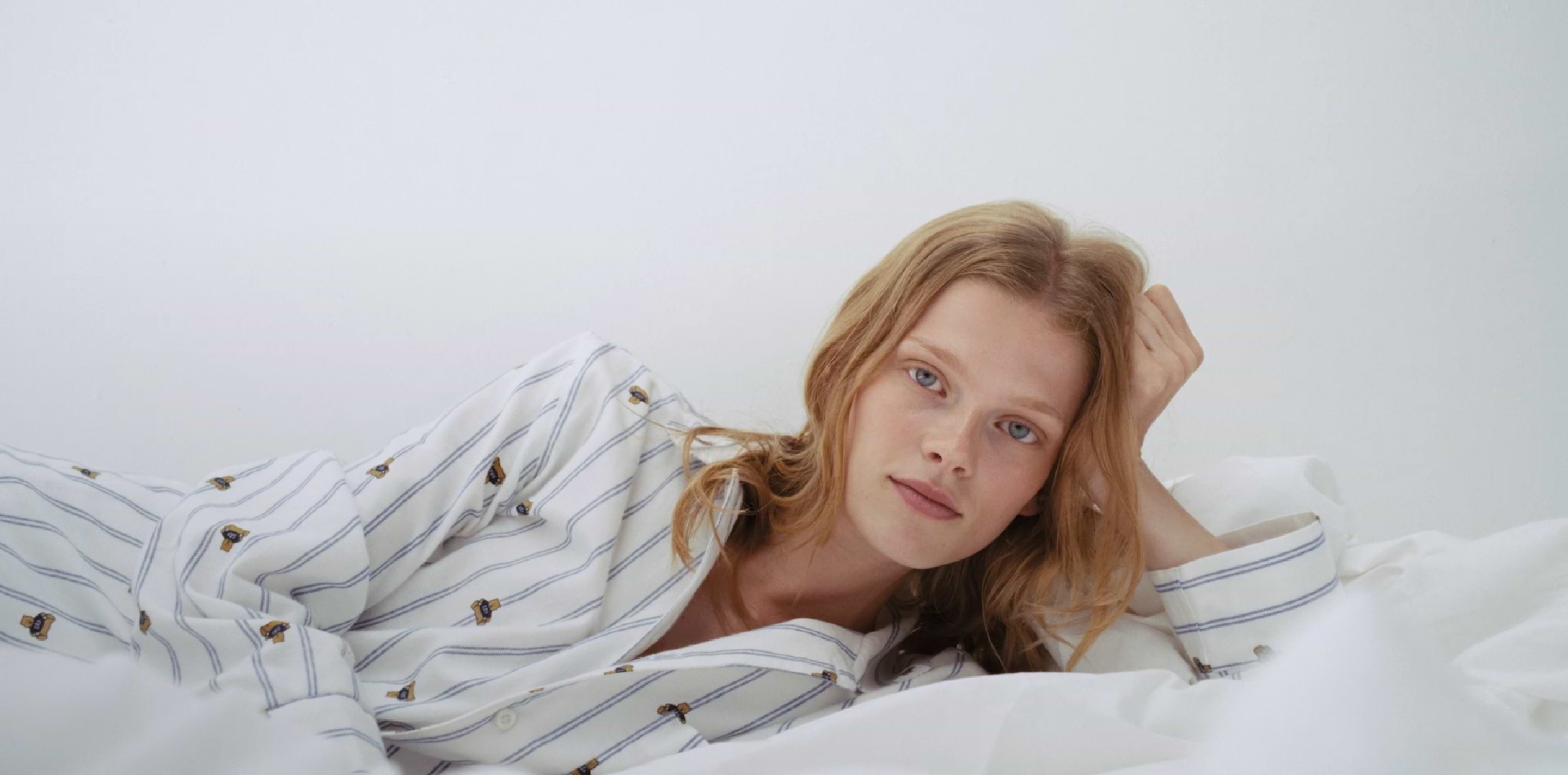 a woman laying on a bed with her head on a pillow