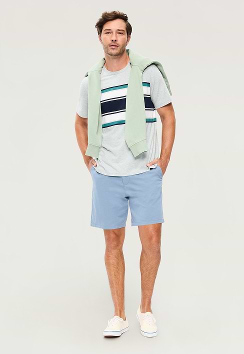 A male model wears light colored Slim Built-In Flex Rotation Chino Shorts