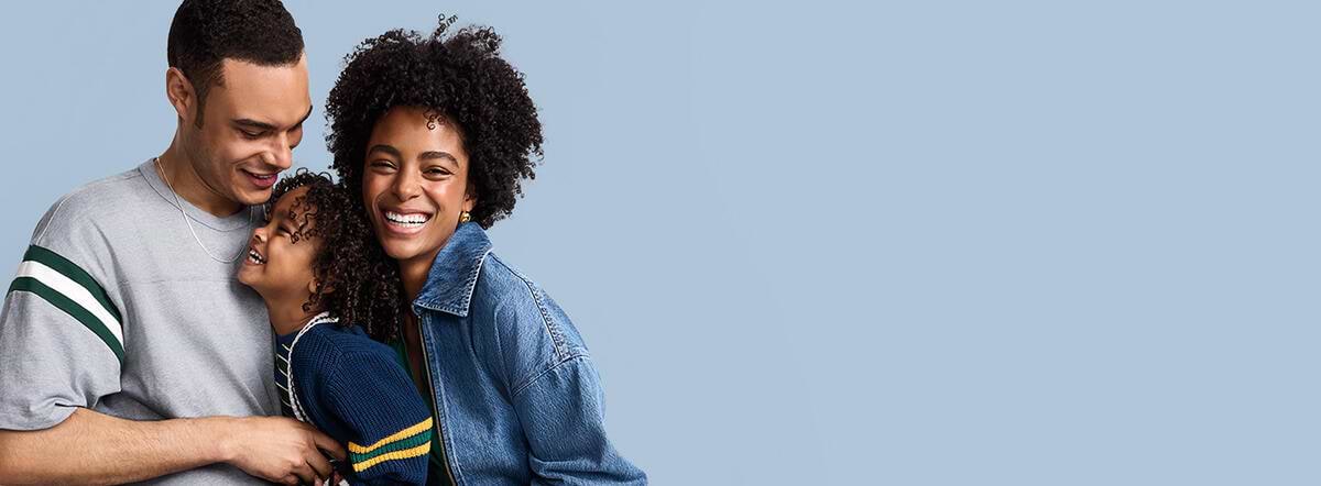 a picture depicting a family of three embracing each other and smiling