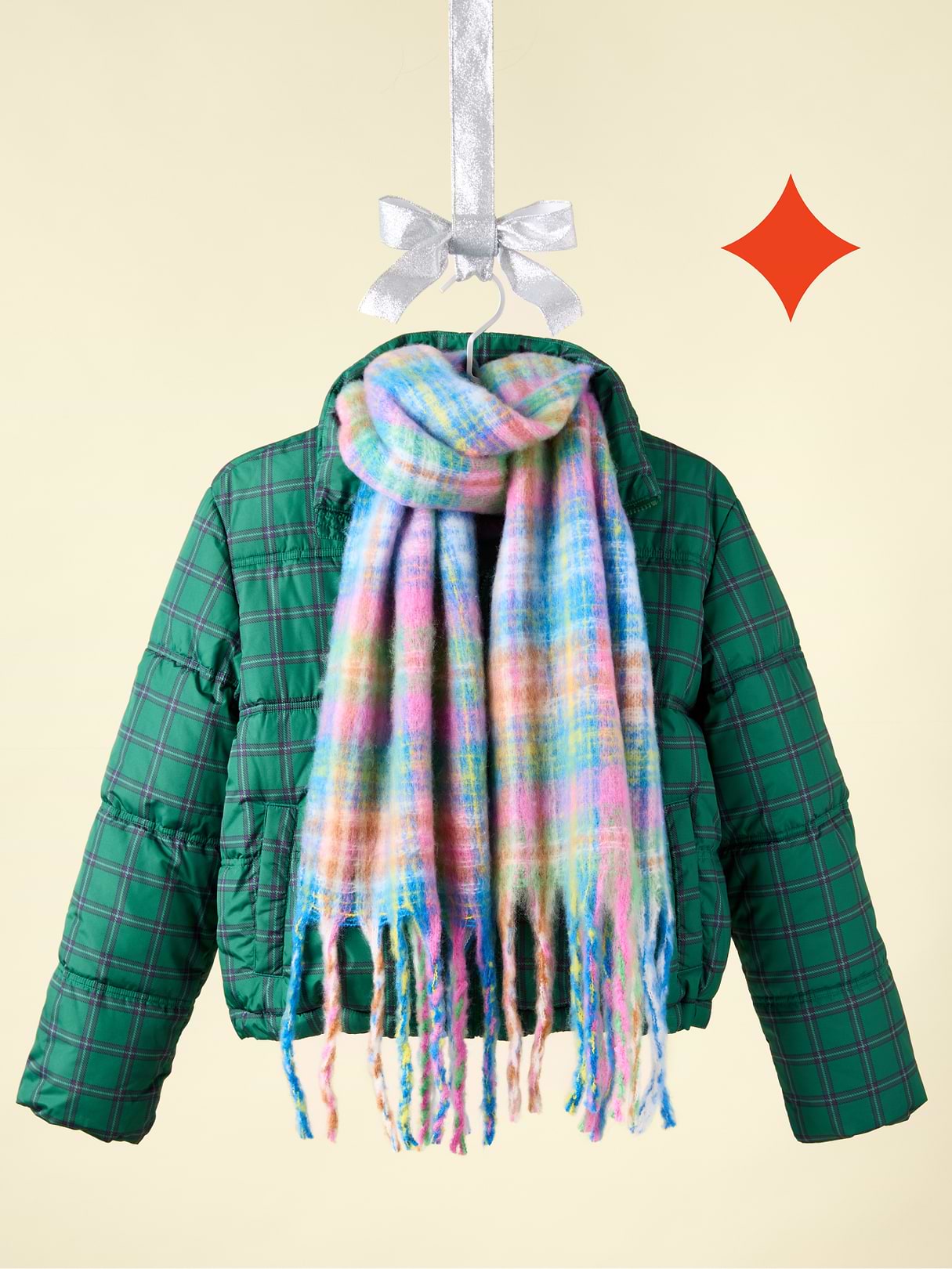 a green jacket and scarf hanging on a hook with a star